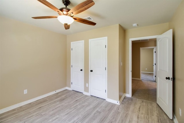unfurnished bedroom with visible vents, baseboards, ceiling fan, and light wood-type flooring