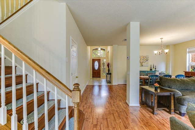 entrance foyer with stairway, a chandelier, and light wood finished floors