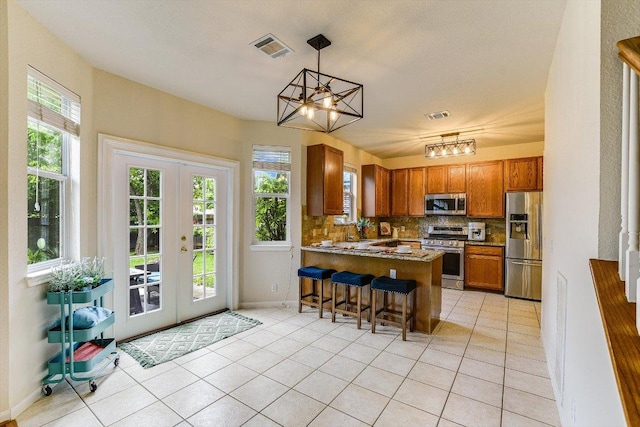 kitchen featuring visible vents, decorative backsplash, a peninsula, french doors, and stainless steel appliances