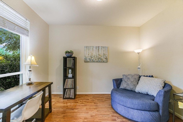 living area with light wood-style floors and baseboards