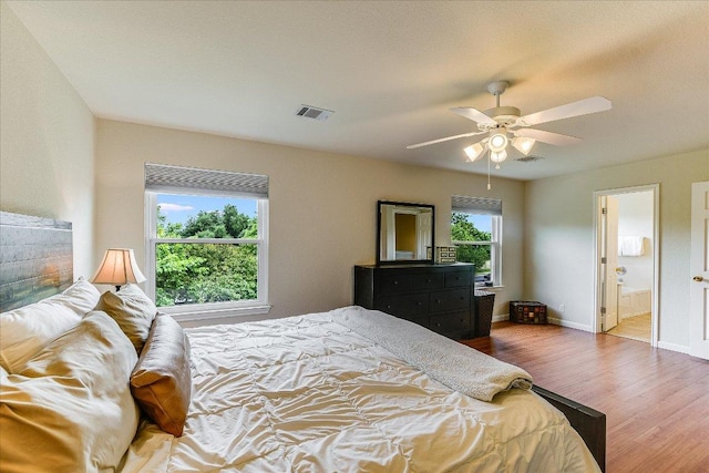 bedroom featuring baseboards, ceiling fan, visible vents, and wood finished floors