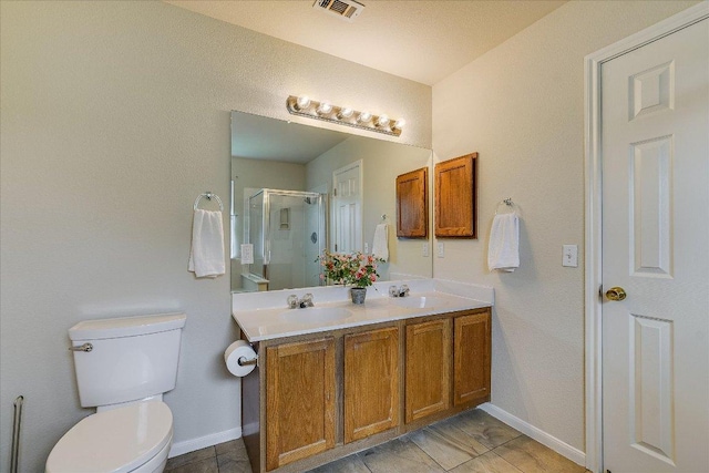 bathroom with baseboards, visible vents, a shower stall, and a sink