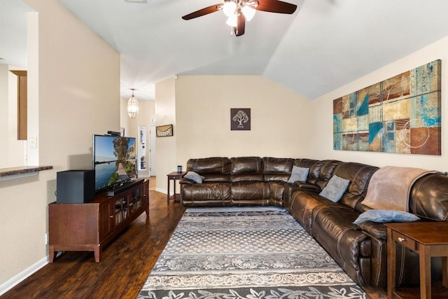 living area with ceiling fan, vaulted ceiling, baseboards, and dark wood-type flooring