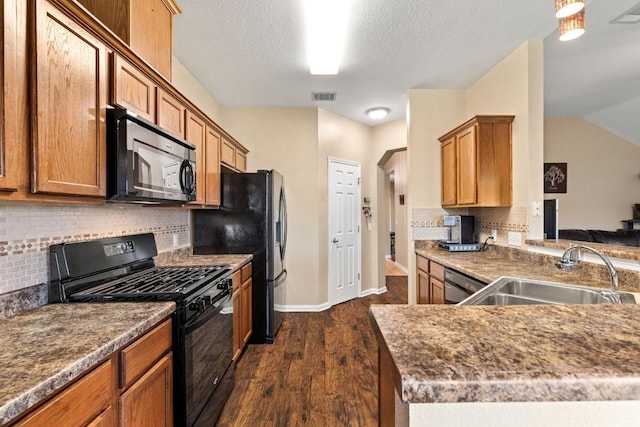 kitchen featuring visible vents, decorative backsplash, dark wood-style flooring, a sink, and black appliances