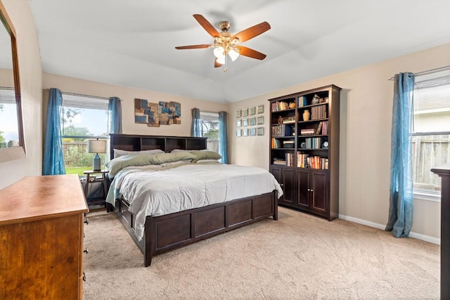 bedroom with multiple windows, ceiling fan, and light colored carpet