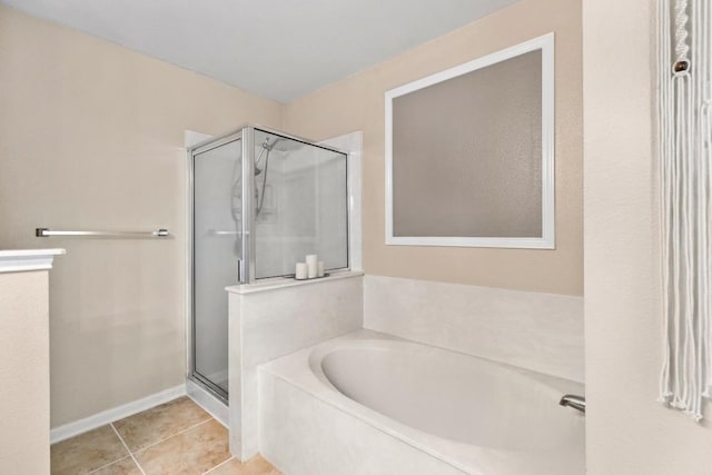 bathroom with tile patterned flooring, a bath, baseboards, and a stall shower