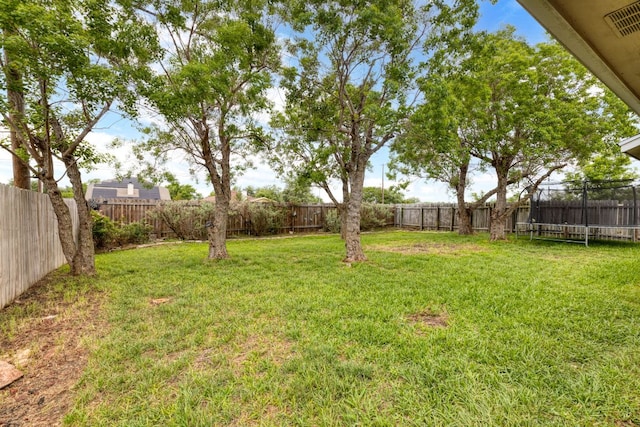 view of yard with a fenced backyard and a trampoline