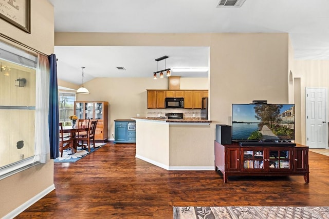 kitchen featuring dark wood-style flooring, decorative light fixtures, black microwave, tasteful backsplash, and a peninsula