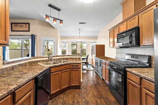 kitchen featuring visible vents, brown cabinets, a sink, dark wood finished floors, and black appliances