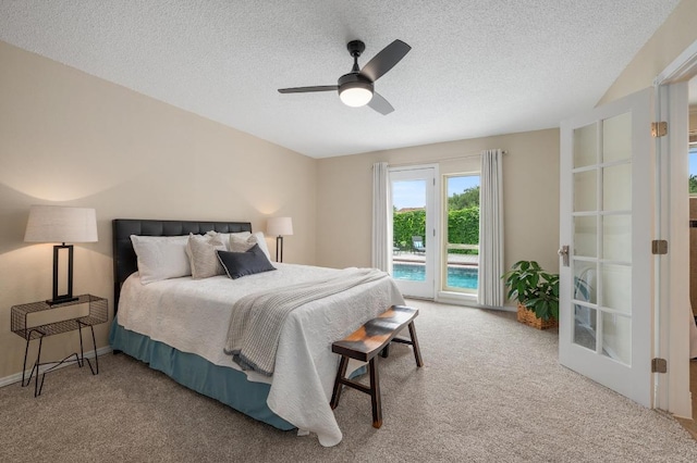 carpeted bedroom with ceiling fan, access to outside, and a textured ceiling