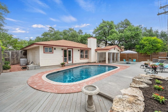 view of swimming pool featuring a deck, a fenced in pool, a fenced backyard, and a patio area