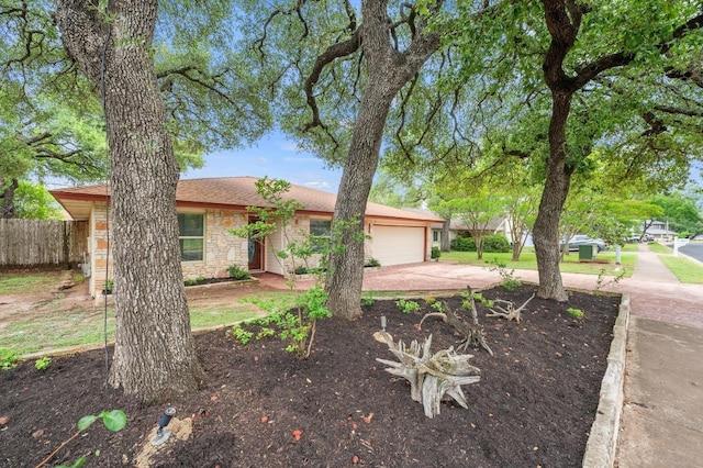 ranch-style house with a garage, fence, stone siding, and concrete driveway