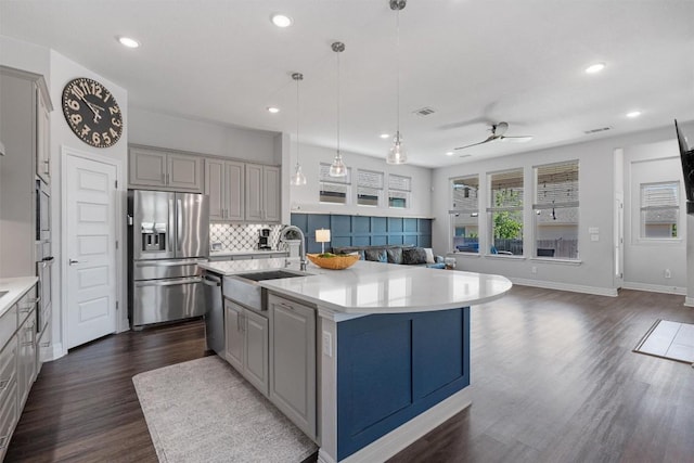 kitchen featuring a sink, appliances with stainless steel finishes, gray cabinets, and open floor plan