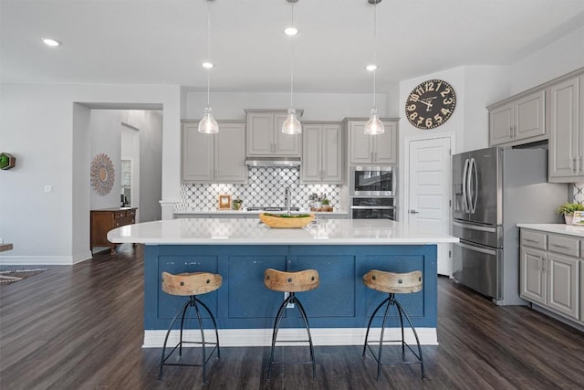 kitchen with light countertops, stainless steel appliances, tasteful backsplash, under cabinet range hood, and gray cabinetry