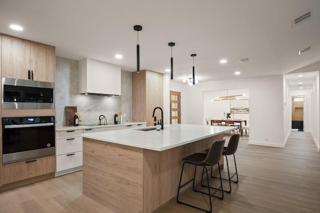 kitchen featuring visible vents, a sink, appliances with stainless steel finishes, and modern cabinets