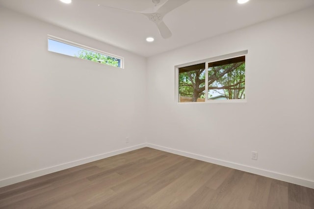 spare room with baseboards, a ceiling fan, recessed lighting, and wood finished floors