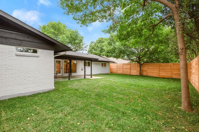 view of yard featuring a patio, a fenced backyard, and french doors