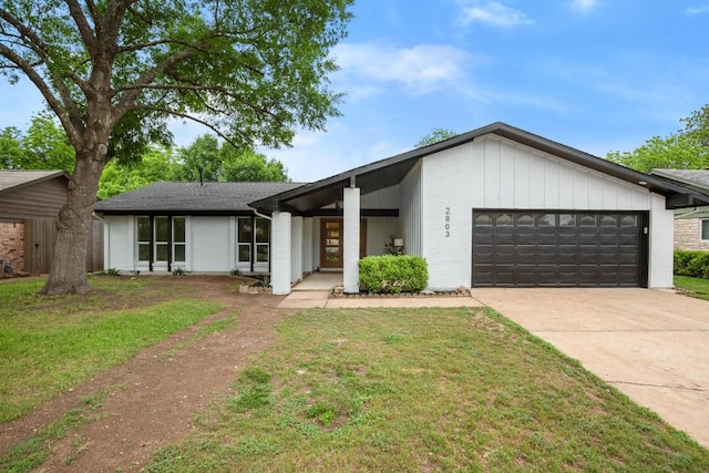 view of front facade with brick siding, a garage, a front yard, and concrete driveway