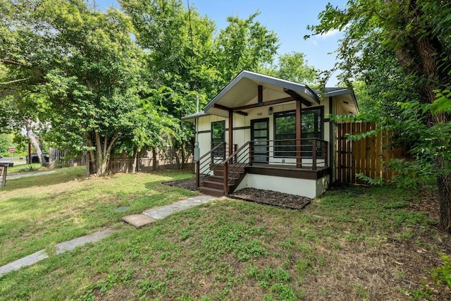 bungalow-style house featuring fence and a front yard