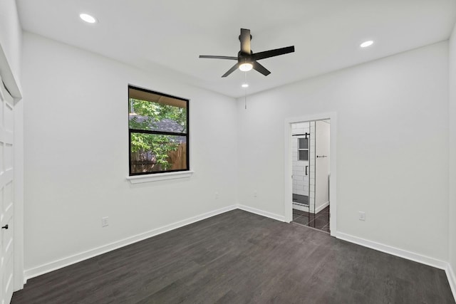 unfurnished bedroom with recessed lighting, baseboards, dark wood-style floors, and ensuite bathroom