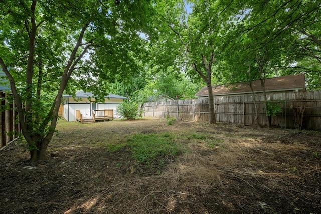 view of yard with a fenced backyard and a wooden deck