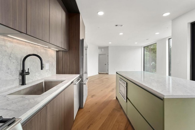 2209 S 1st St Unit 206, Austin, TX 78704 - kitchen with a sink, appliances with stainless steel finishes, tasteful backsplash, recessed lighting, and light wood finished floors