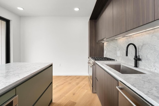 2209 S 1st St Unit 206, Austin, TX 78704 - kitchen featuring stainless steel appliances, a sink, backsplash, recessed lighting, and light wood-style flooring