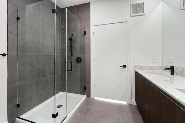 2209 S 1st St Unit 206, Austin, TX 78704 - bathroom with double vanity, a stall shower, tile patterned flooring, and baseboards