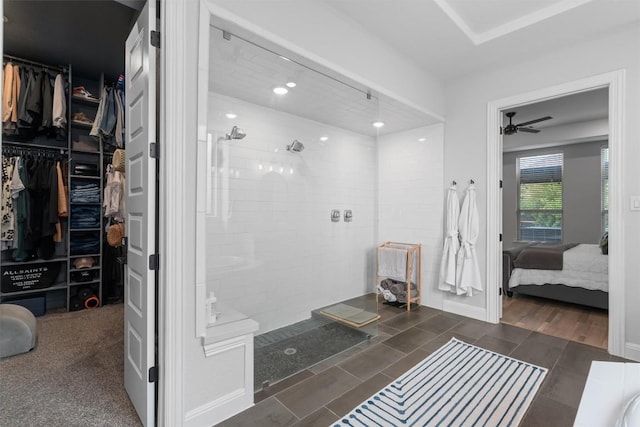 bathroom with a ceiling fan, connected bathroom, a walk in closet, and walk in shower