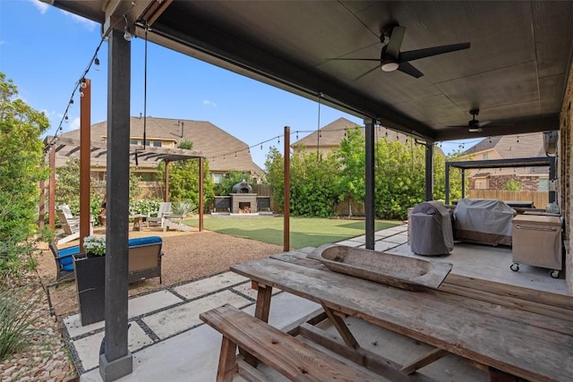 view of patio / terrace featuring an outdoor fireplace, a fenced backyard, ceiling fan, and grilling area