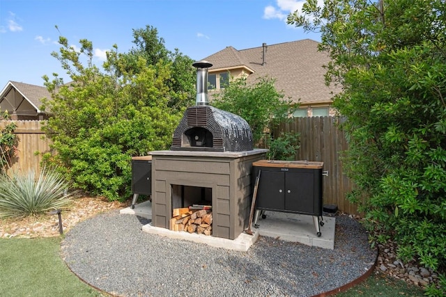 exterior space with an outdoor fireplace and fence