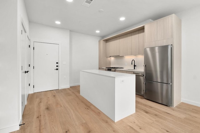 kitchen with a kitchen island, stainless steel appliances, recessed lighting, and light countertops