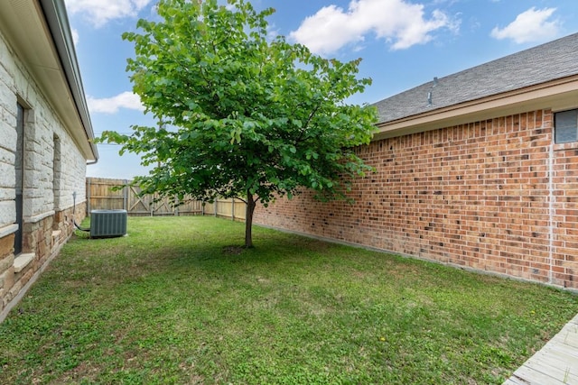 view of yard with central AC unit and a fenced backyard