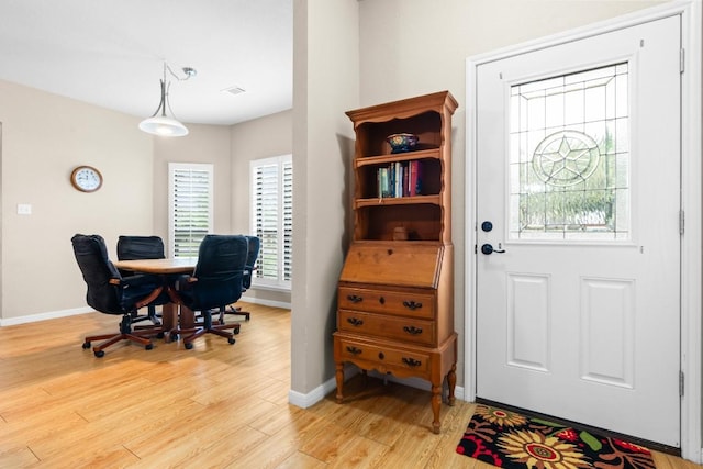 office space featuring baseboards, light wood finished floors, and visible vents