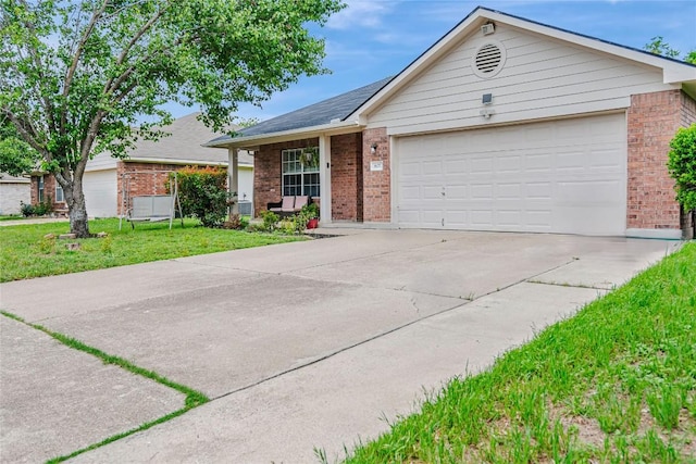 ranch-style home with brick siding, an attached garage, driveway, and a front yard