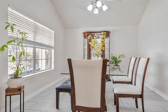 dining area featuring baseboards, ceiling fan, and vaulted ceiling
