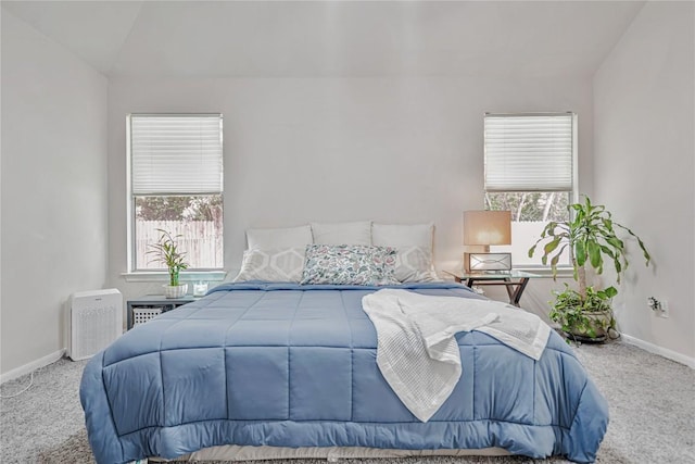 bedroom featuring carpet floors, baseboards, vaulted ceiling, and multiple windows