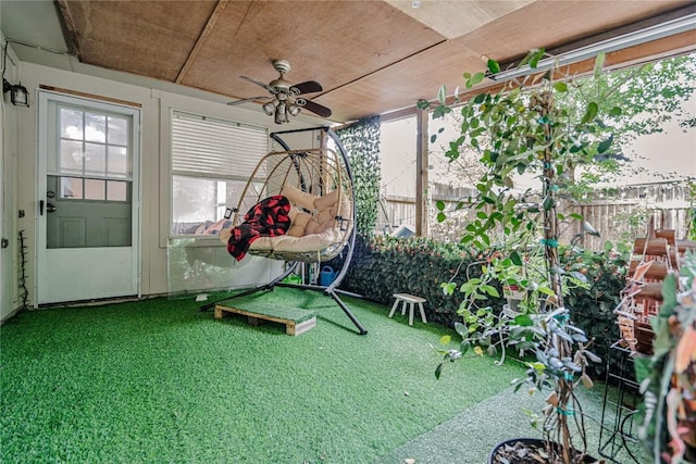 unfurnished sunroom with ceiling fan