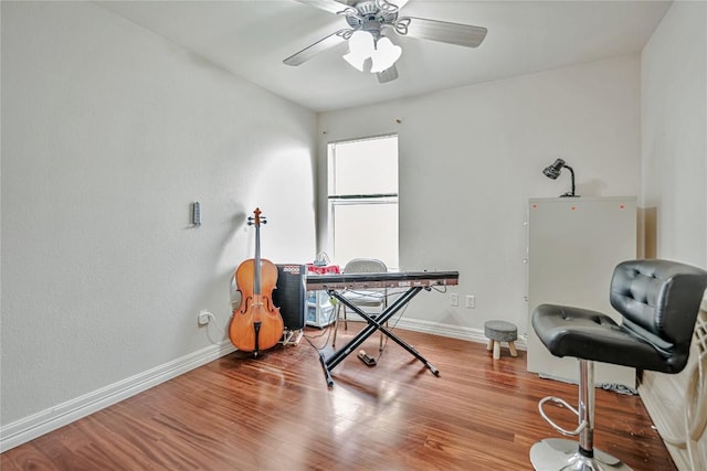 office space featuring baseboards, ceiling fan, and wood finished floors