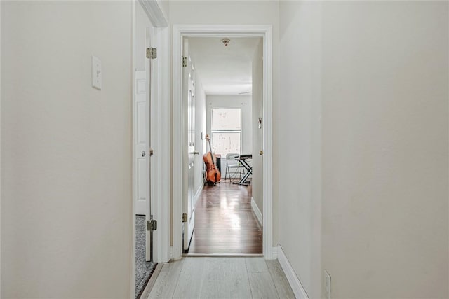 hallway featuring baseboards and wood finished floors
