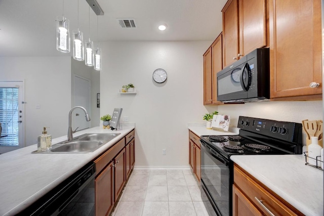 kitchen with a sink, light countertops, brown cabinetry, visible vents, and black appliances