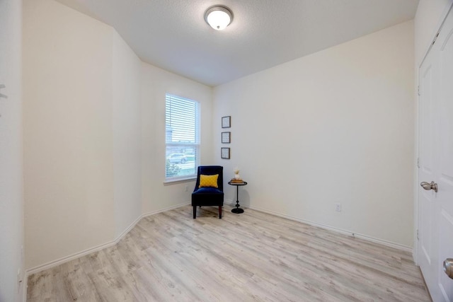 unfurnished room with baseboards and light wood-style flooring