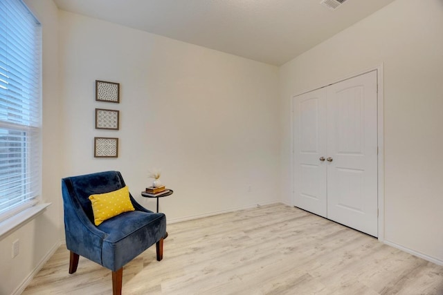living area featuring baseboards and light wood-type flooring