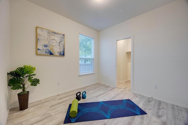 exercise room featuring baseboards and wood finished floors