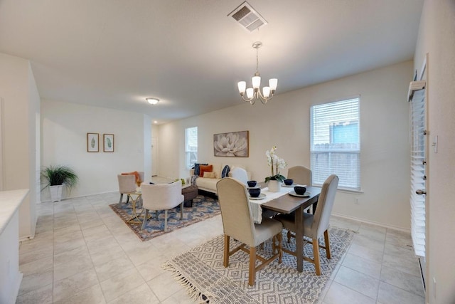 dining area featuring visible vents, light tile patterned flooring, and an inviting chandelier