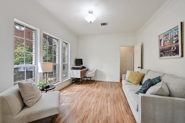 living area featuring crown molding, baseboards, wood finished floors, and visible vents
