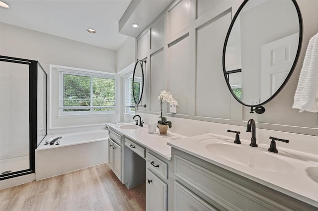 5908 Front Royal Dr, Austin, TX 78746 - full bath with a shower stall, double vanity, a garden tub, wood finished floors, and recessed lighting