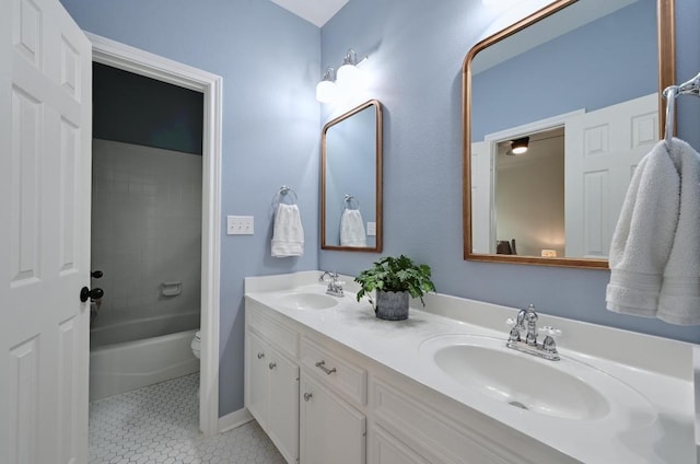 full bath featuring double vanity, toilet, a sink, and tile patterned flooring