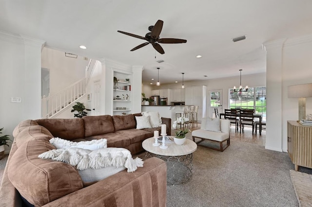 living room featuring stairs, recessed lighting, crown molding, and ceiling fan with notable chandelier