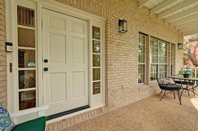 entrance to property with brick siding and covered porch